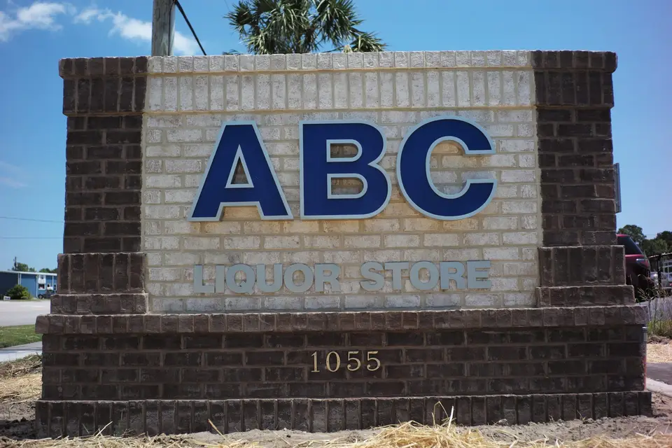 ABC Liquor Store monument sign with blue letters and the number 1055