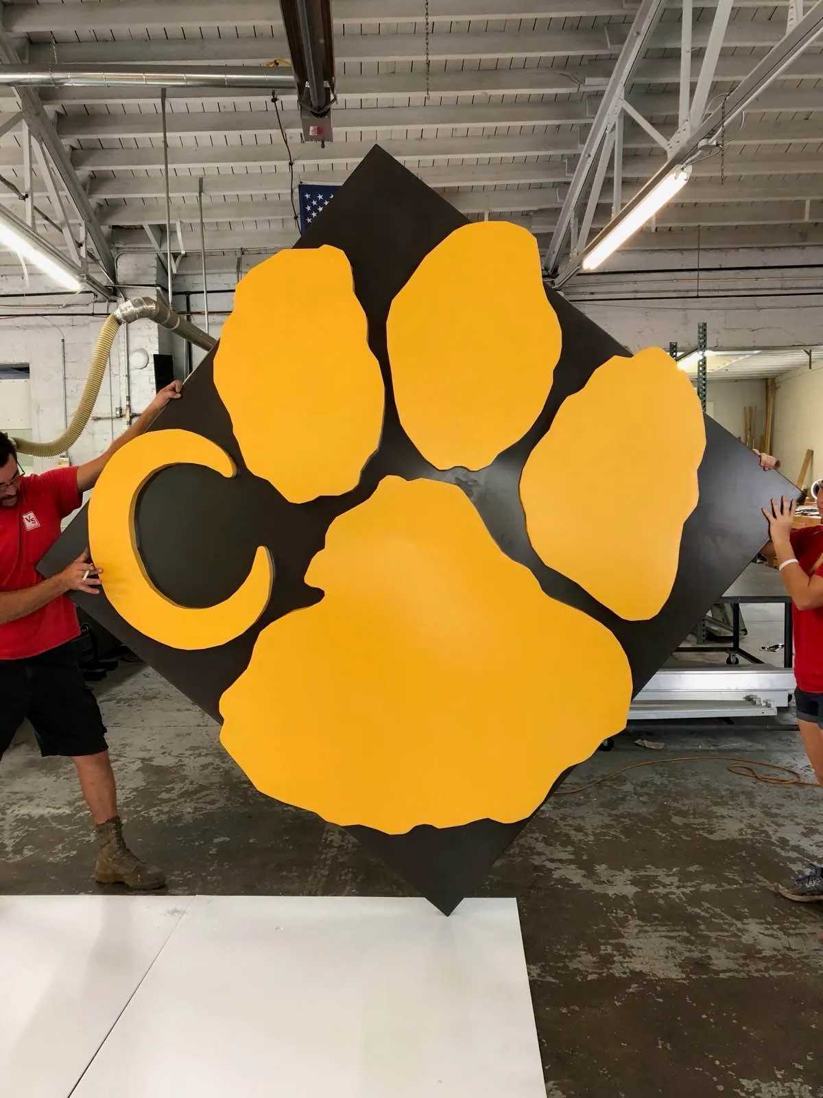 Team holding fabricated sign
